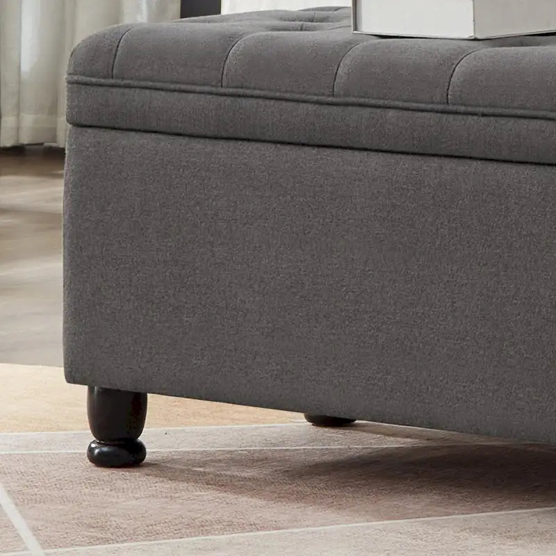 Banc de rangement capitonné en lin gris foncé avec pieds fuselés en bois